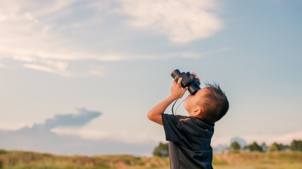 Enfant regarde le ciel avec des jumelles